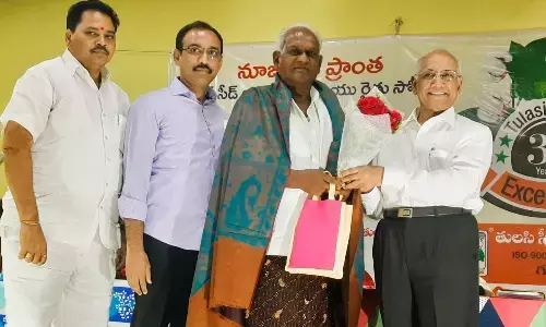 Tulasi Seeds chairman Tulasi Ramachandra Prabhu felicitating a cotton farmer, who achieved highest yield in the production of artificial seeds, at Govardhan Gardens in Vadlamanu village on Thursday