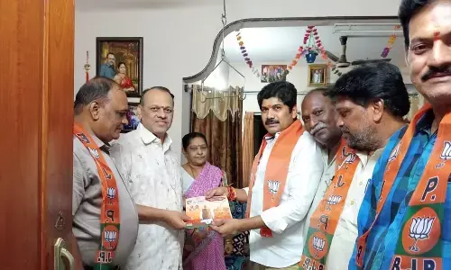 Central Labour Welfare Board Chairman Valluru Jayaprakash Narayana distributing pamphlets to the residents in Guntur on Thursday