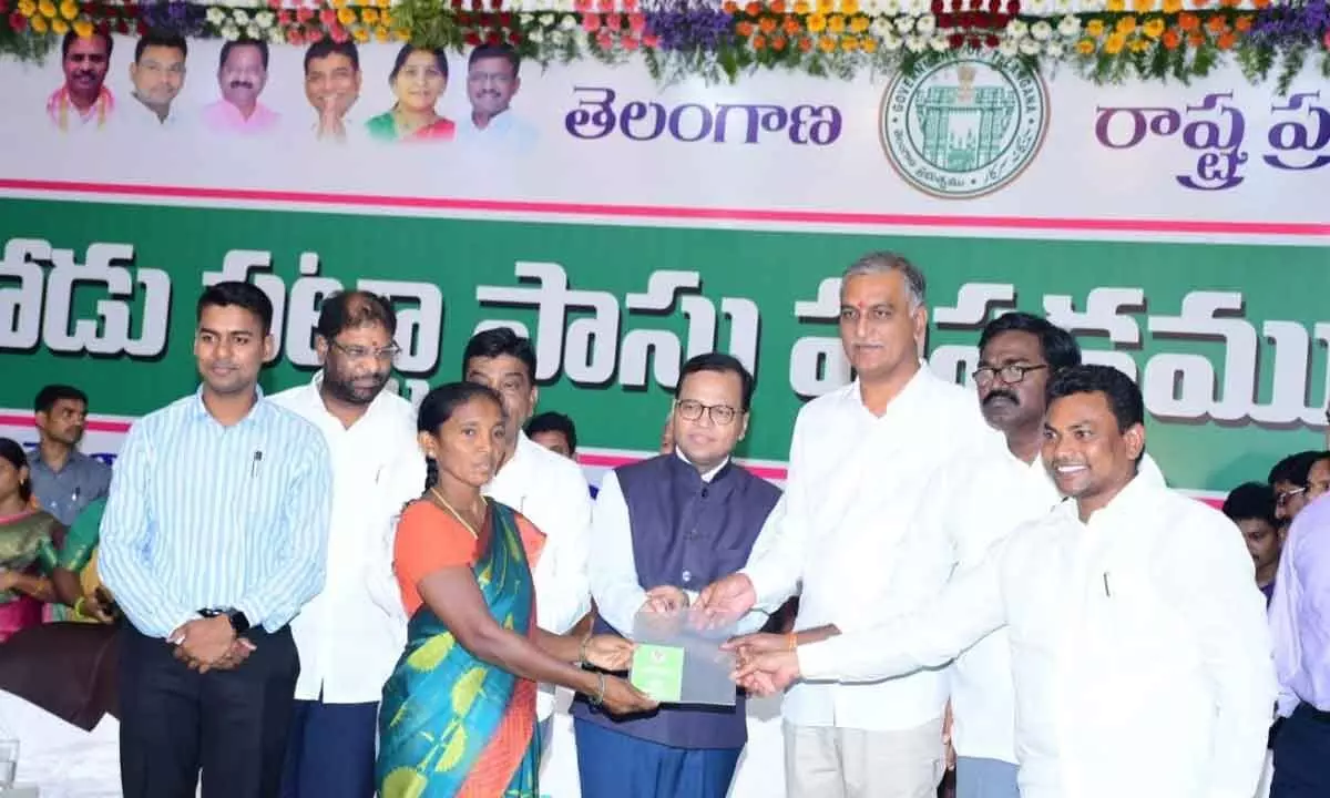 Minister for Finance T Harish Rao distributing Podupattas to tribal farmers in Kothagudem on Friday.