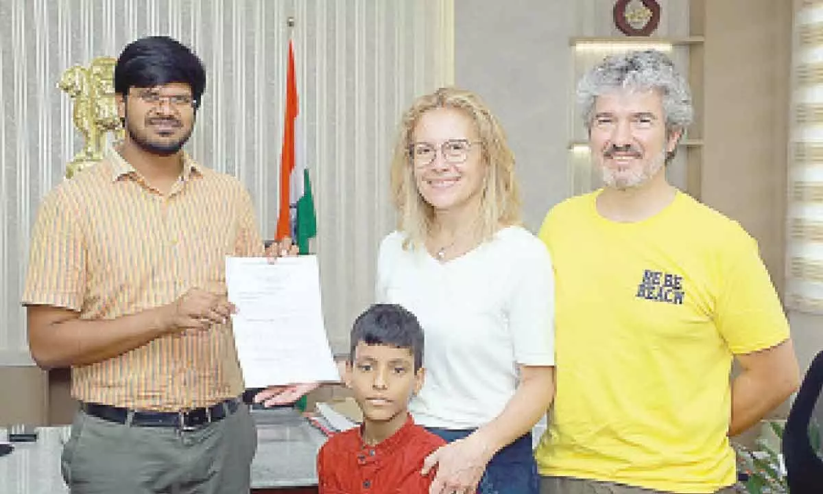 District Collector VP Gautham along with an Italian couple who adopted a child, at his office in Khammam on Monday.