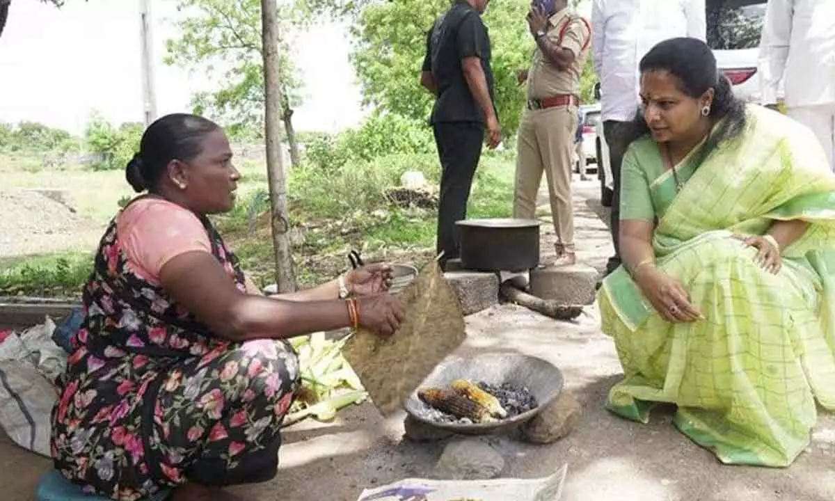 MLC Kavitha interacts with roadside grilled corn seller in Jagtial