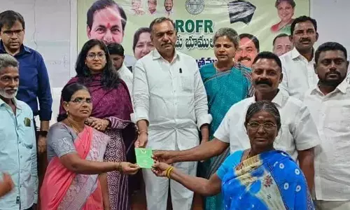 Bhupalpally MLA Gandra Venkatramana Reddy along with Warangal Zilla Parishad chairperson Gandra Jyothy and Hanumakonda district collector Sikta Patnaik distributing ownership titles of podu land to beneficiaries in Hanumakonda on Monday