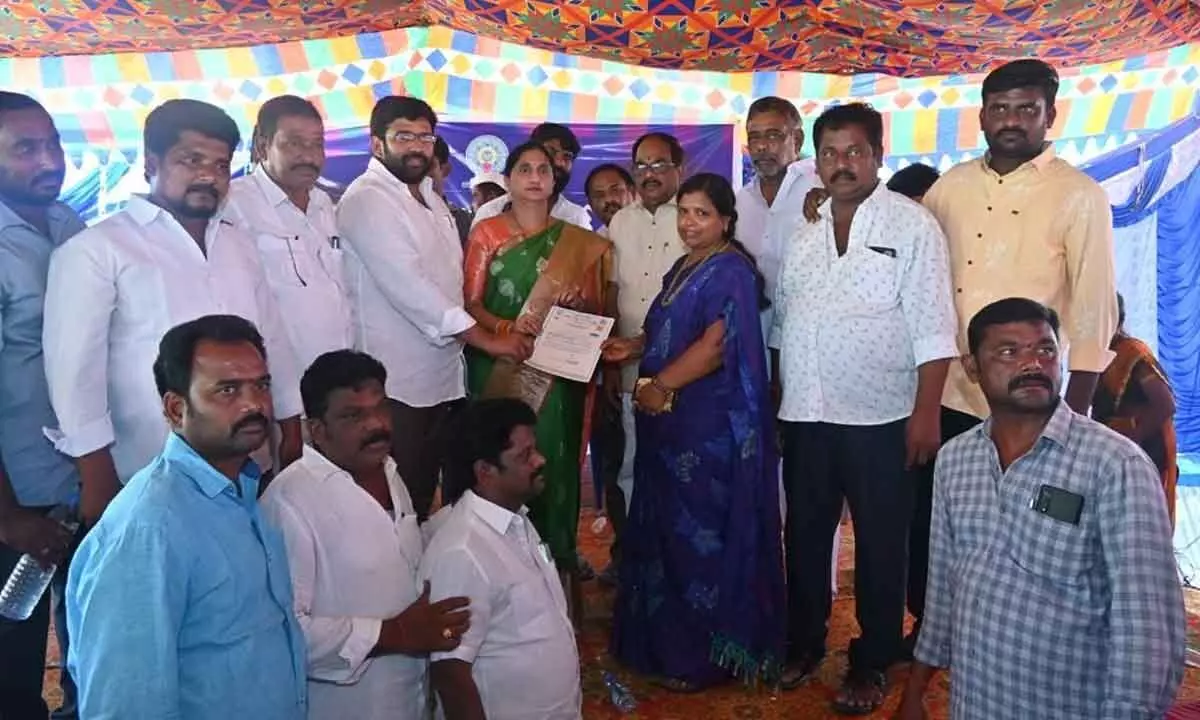 Collector Madhavi Latha, MLA Jakkampudi Raja and others presenting certificate to woman in Rajanagaram on Tuesday