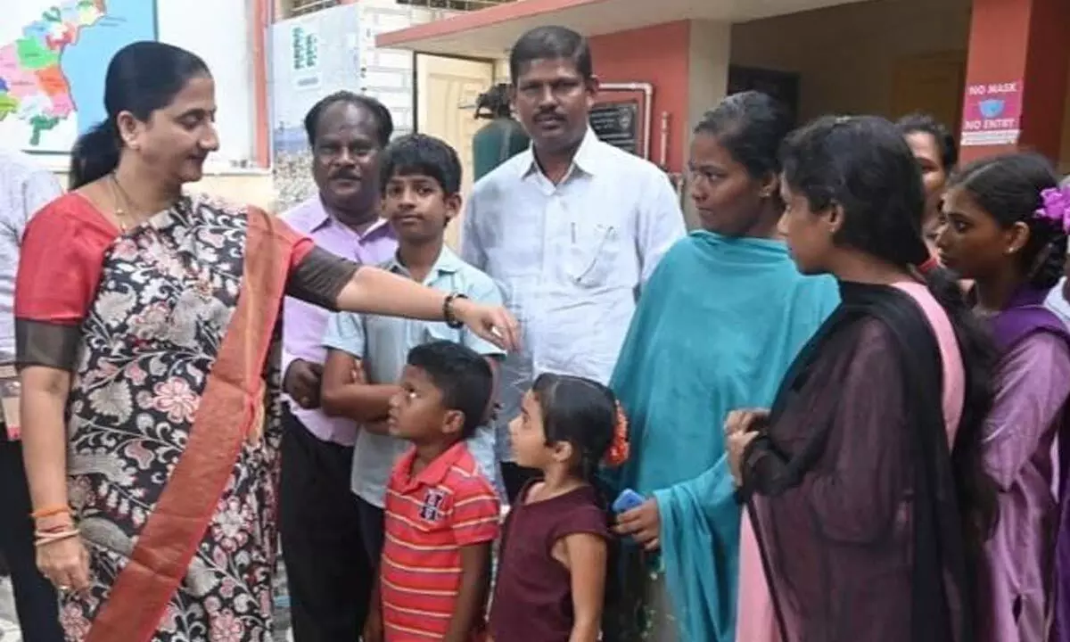 District Collector Madhavi Latha, DEO S Abraham and others with the children, who are admitted again in school, in Rajamahendravaram on Wednesday