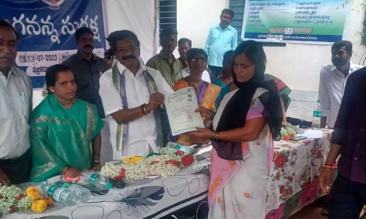 MLC Y Sivarami Reddy distributing certificate to a woman under Jagananna Suraksha programme held at Vajra Karur in Anantapur on Friday