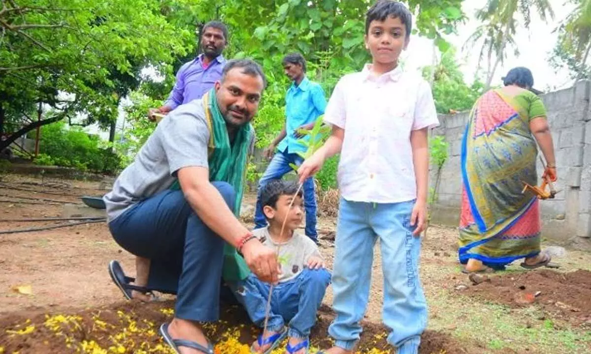 Collector RV Karnan along with his children planted saplings at the district Collectorate in Karimnagar on Monday