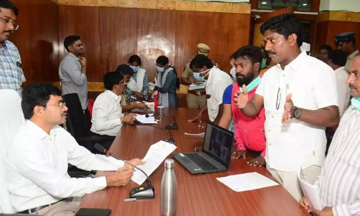 Jana Sena Party corporator Peethala Murthy Yadav briefing Collector A Mallikarjuna on land encroachment during grievance platform in Visakhapatnam on Monday