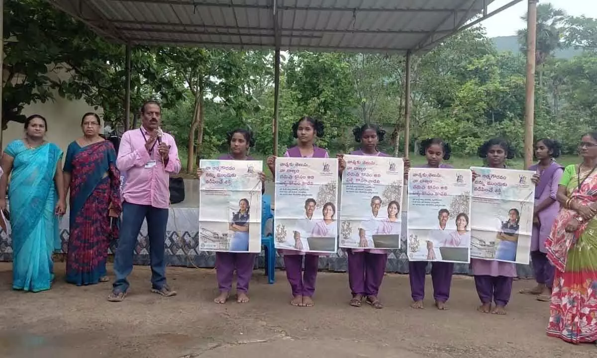 SBCC coordinator B Ramakrishna and others unveiling wall posters on the prevention of child  marriages, at Nellimarla Gurukul School in Vizianagaram on Monday