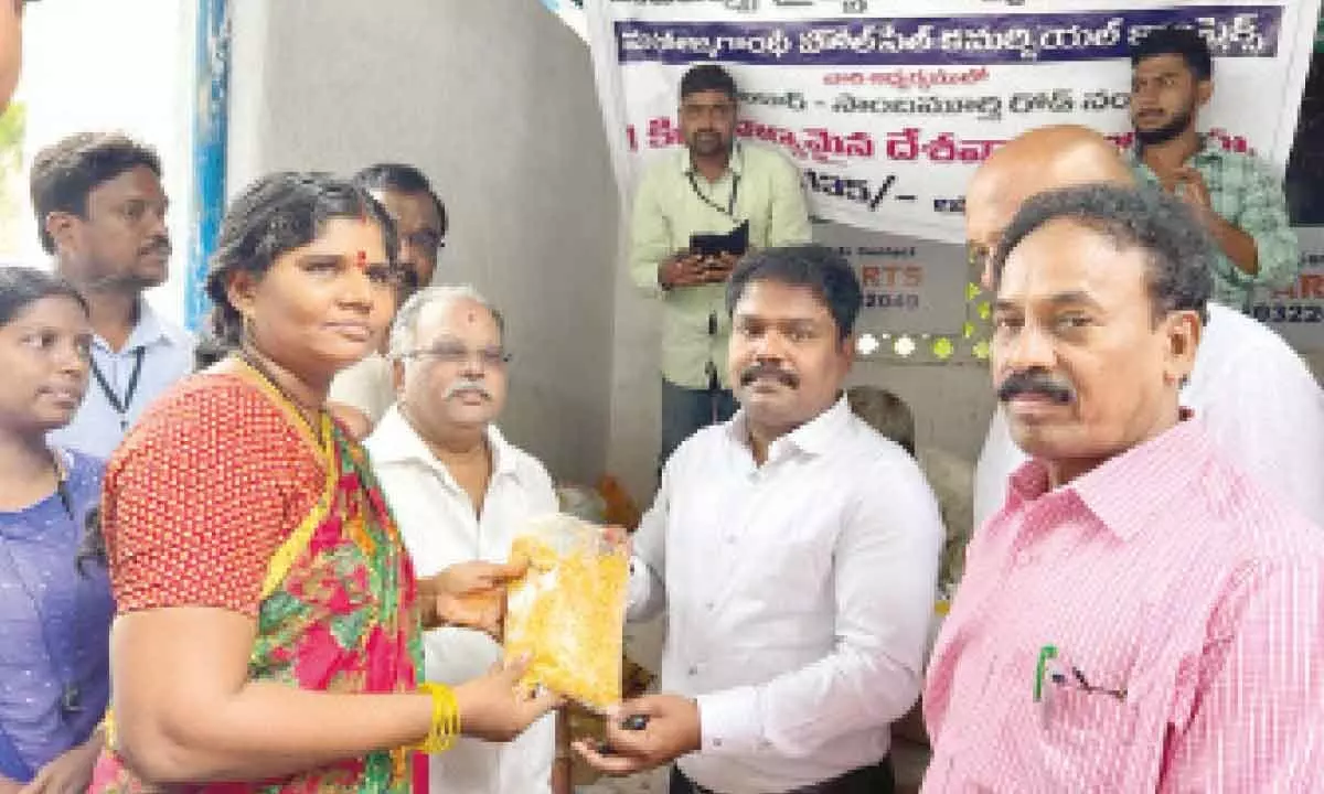 NTR district Joint Collector P Samapath Kumar handing over red gram to a consumer in Vijayawada on Monday
