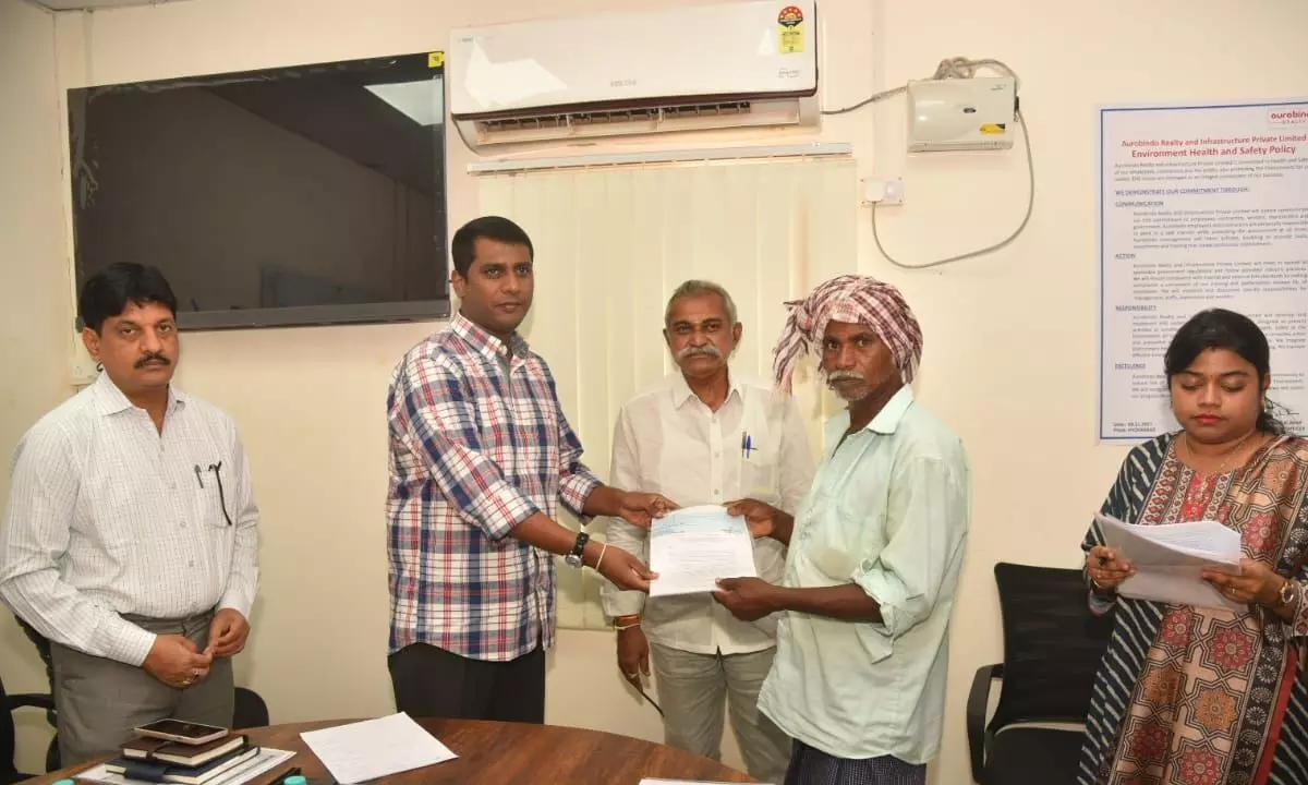 Nellore District Collector M Harinarayanan handing over a cheque to the displaced families of Ramayapatnam Port in Ramayapatnam village on Wednesday. Kandukuru MLA  M Maheedhar Reddy and others are also seen.