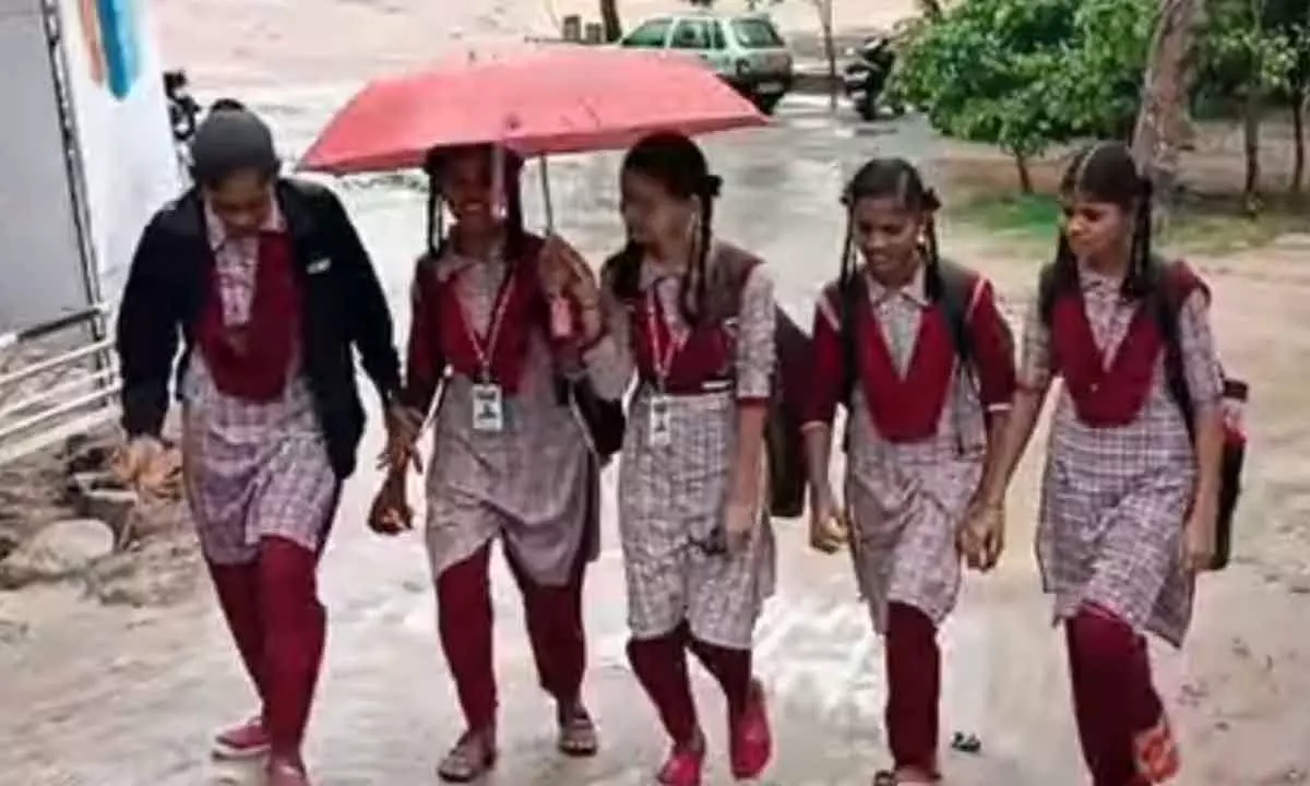 School girls on their way to school in rains in Jadcherla on Thursday