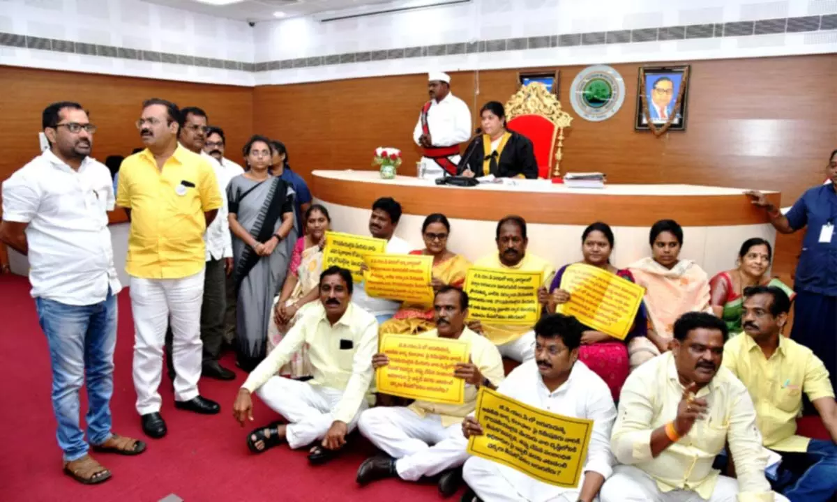 Corporators of opposition parties displaying placards and protesting at the podium during the council meeting of the GVMC in Visakhapatnam on Tuesday