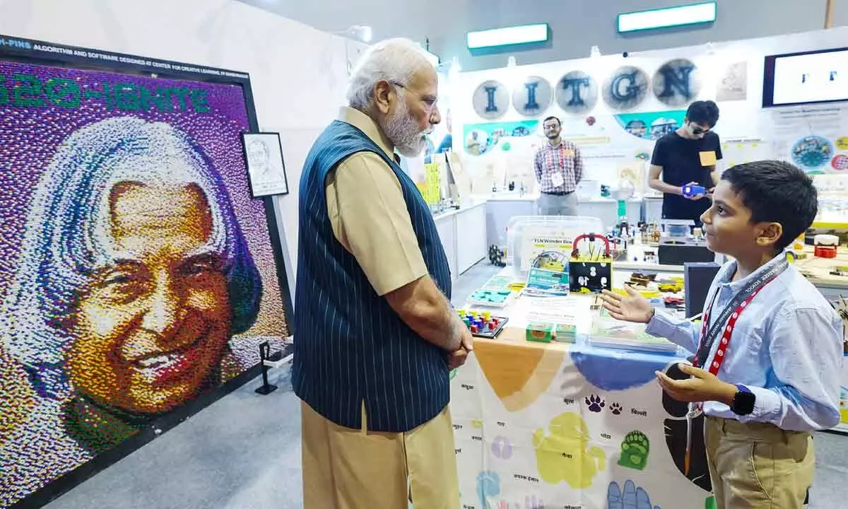 Prime Minister Narendra Modi interacts with a student during an exhibition at the inauguration of Akhil Bhartiya Shiksha Samagam, at Bharat Mandapam in New Delhi on Saturday