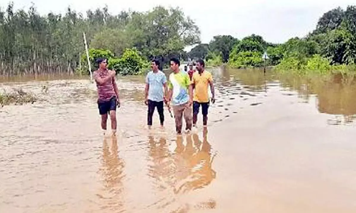 People walking in floodwater in Yetapaka mandal