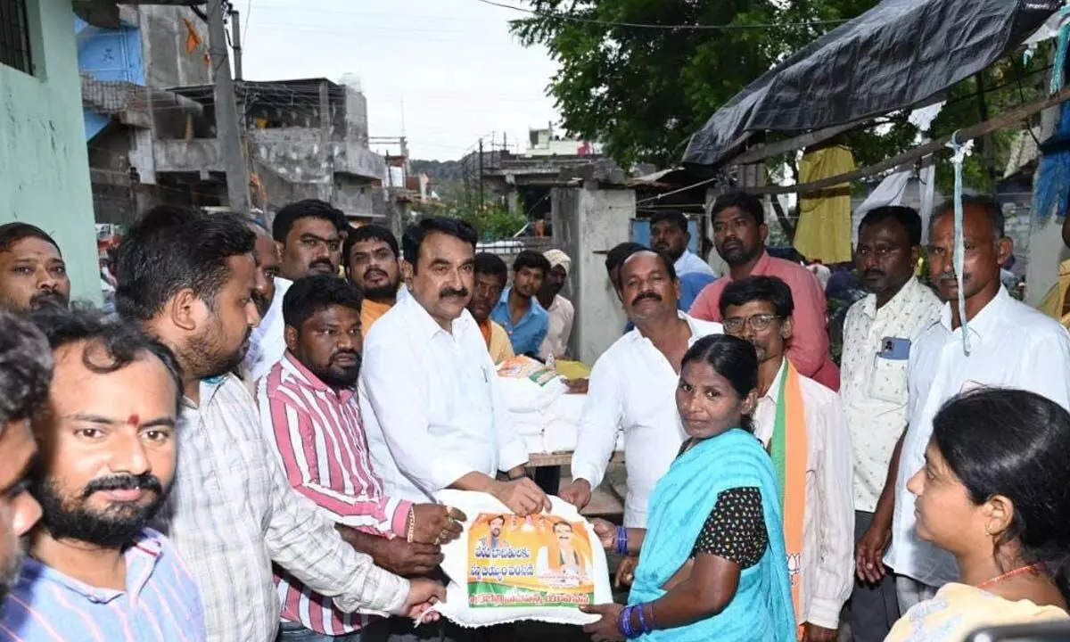 Warangal Urban Cooperative Bank chairman and BJP leader Errabelli Pradeep Rao distributing rice and bedsheets to flood victims in Warangal on Sunday