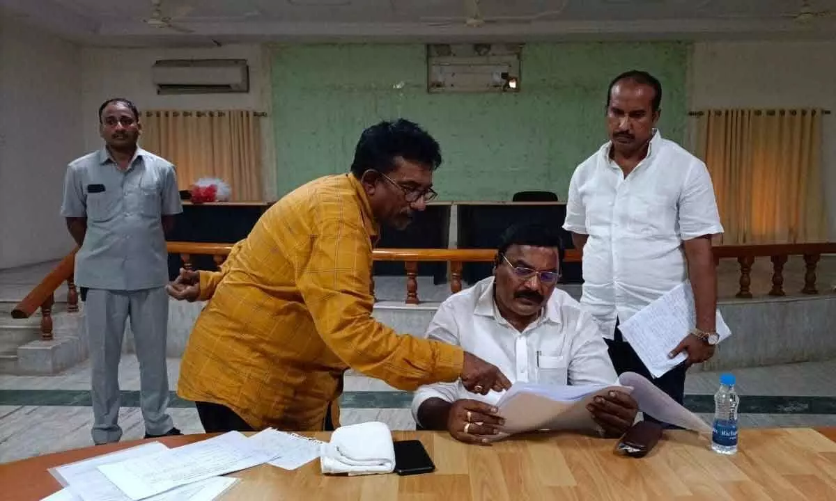 Minister Merugu Nagarjuna examining the records in the review meeting