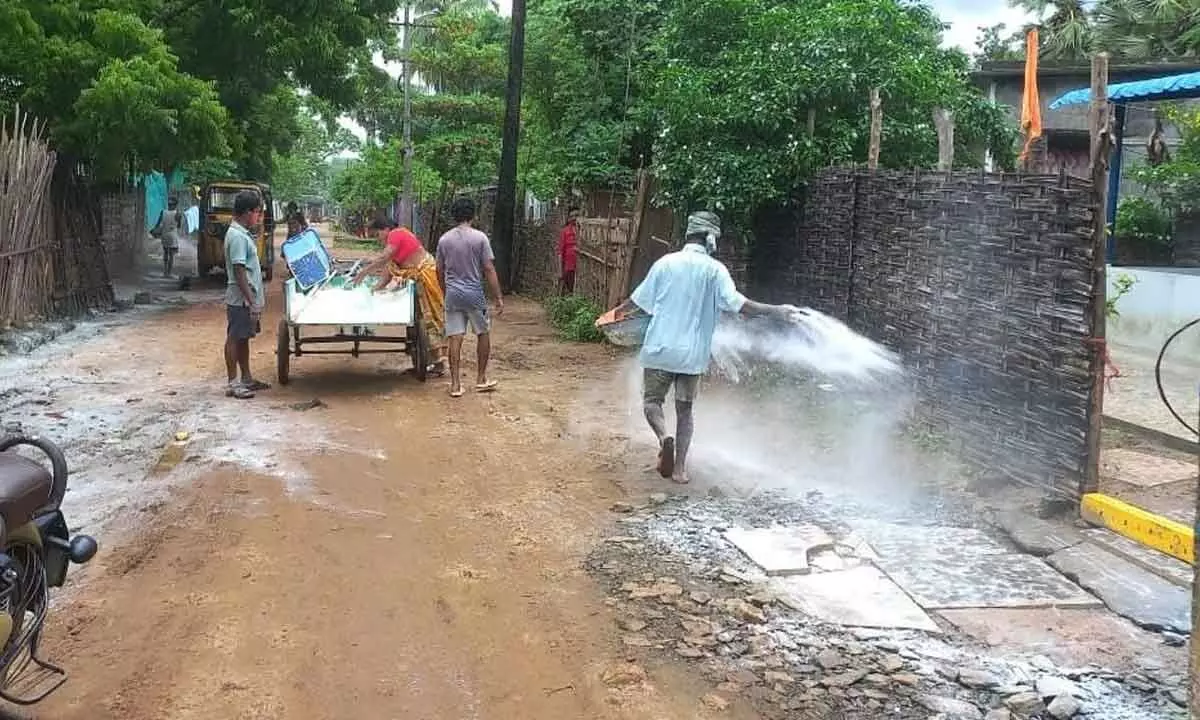 Sanitary staff spraying bleaching in the streets in flooded villages in Chinturu mandal on Tuesday