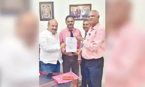 QIS Engineering College Chairman Dr N Surya Kalyan Chakravarti and Principal Dr YV Hanumanta Rao congratulating Mathematics Assistant Professor Telikapalli Srinivas after he was awarded Ph D in the college premises in Vegamukkapalem on Monday