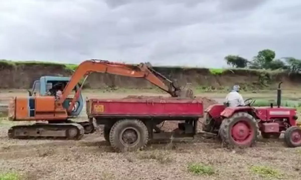 Sand being excavated in Kundu river with the help of an earth mover in Nandyal