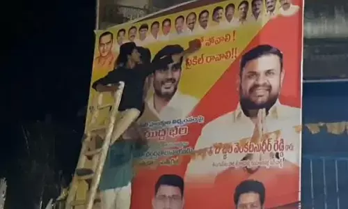 Muncipal staff removing a flexi of TDP in Srikalahasti on Saturday.