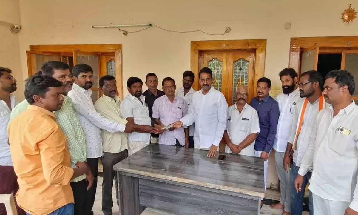 Congress leader Patel Ramesh Reddy handing over a cheque for Rs 50,0000 to Ambedkar statue installation committee at Balemla village in Suryapet district on Monday