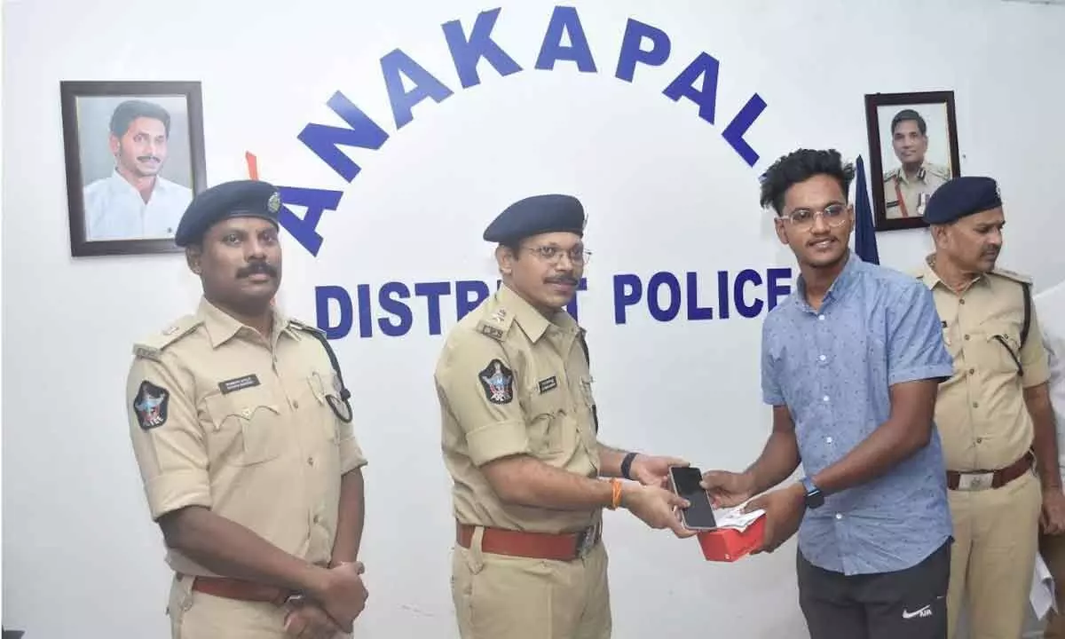 Anakapalli Superintendent of Police KV Murali Krishna handing over a recovered mobile phone to the owner in Anakapalli district on Tuesday.