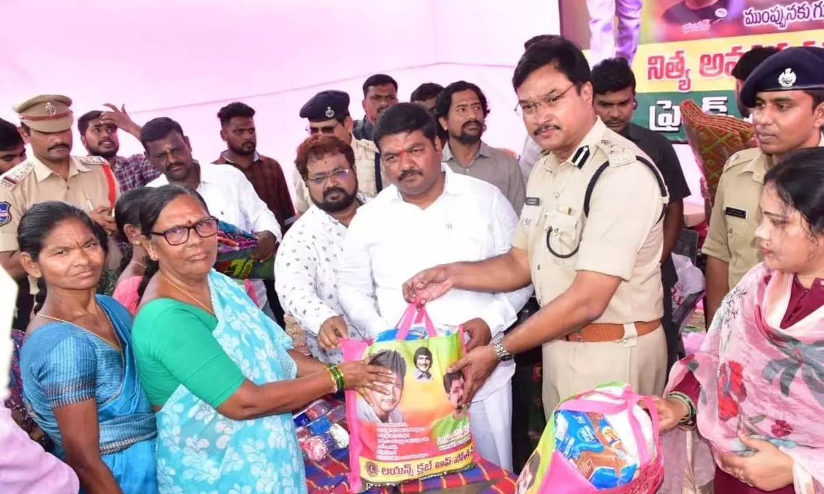 Warangal East MLA Nannapuneni Narender and Commissioner of Police A V Ranganath distributing essentials to flood-affected residents at NTR Nagar in Warangal on Wednesday