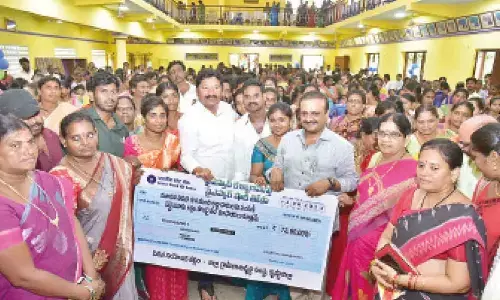 Housing Minister Jogi Ramesh and Machilipatnam MP V Balasoury handing over cheque to the beneficiaries at Pedana on Monday