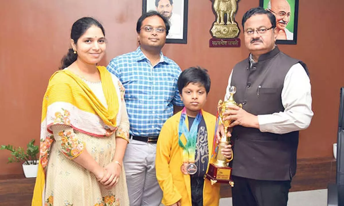 District Collector K Venkataramana Reddy congratulating the Anirudh Sriram in Tirupati on Monday. His parents are also seen.