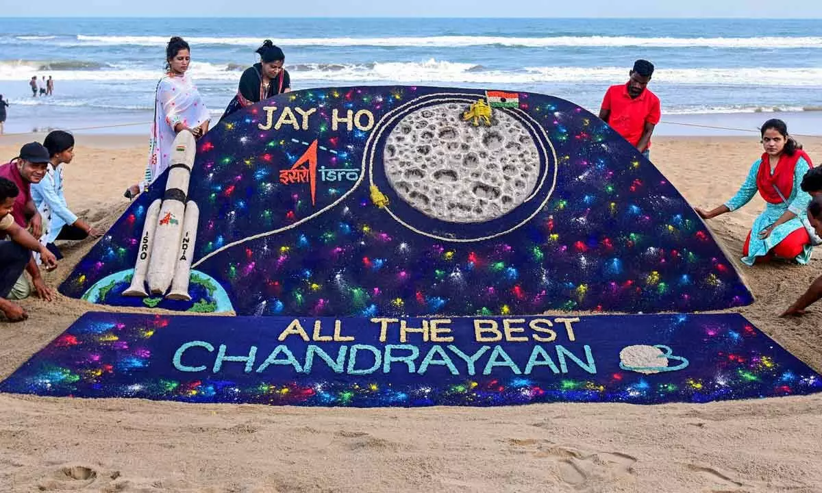 Students of Sudarsan Sand Art Institute create a sand art on ISRO’s lunar mission Chandrayaan-3 at the beach, in Puri on Tuesday