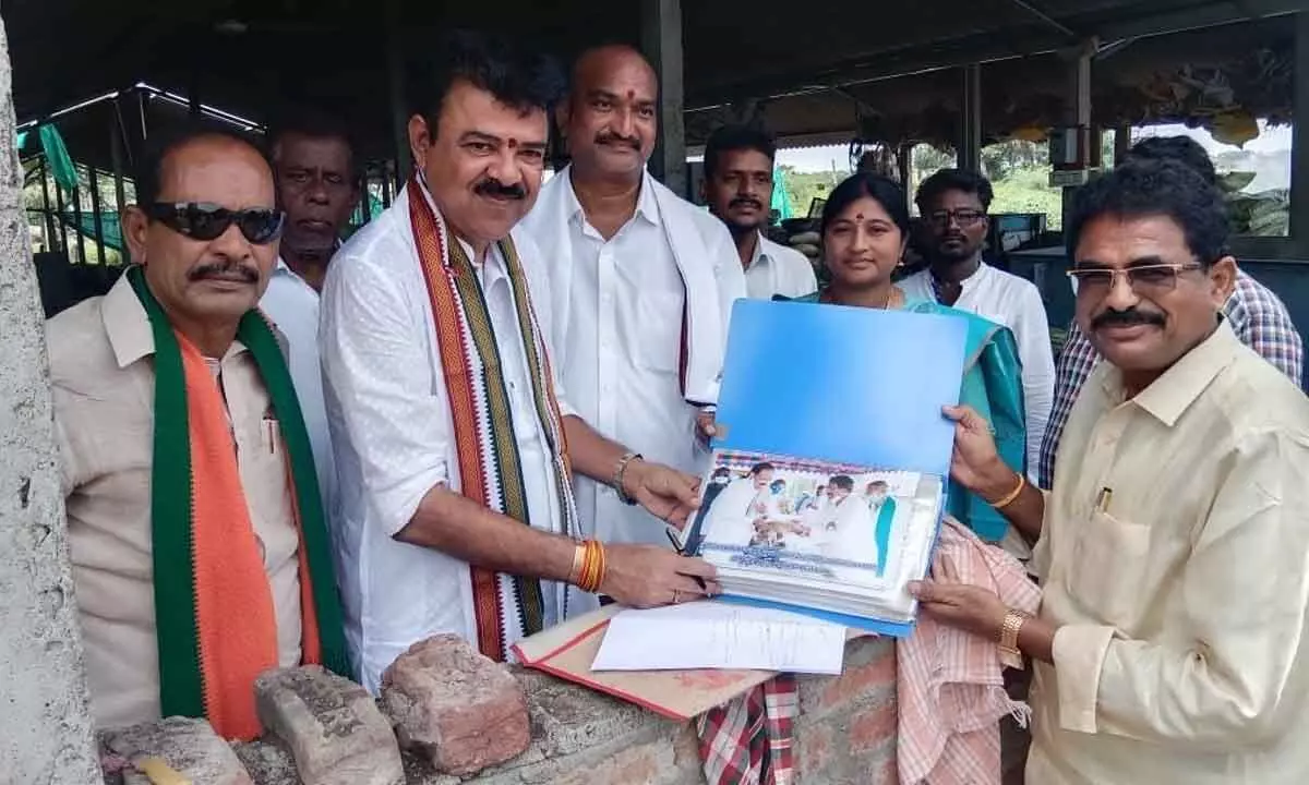 Odisha state Brahmagiri MLA LB Mahapatro along with BJP leader Kondapalli Sridhar Reddy explaining Central schemes to the people in Nelakondapalli under Palair assembly segment in Khammam district on Wednesday