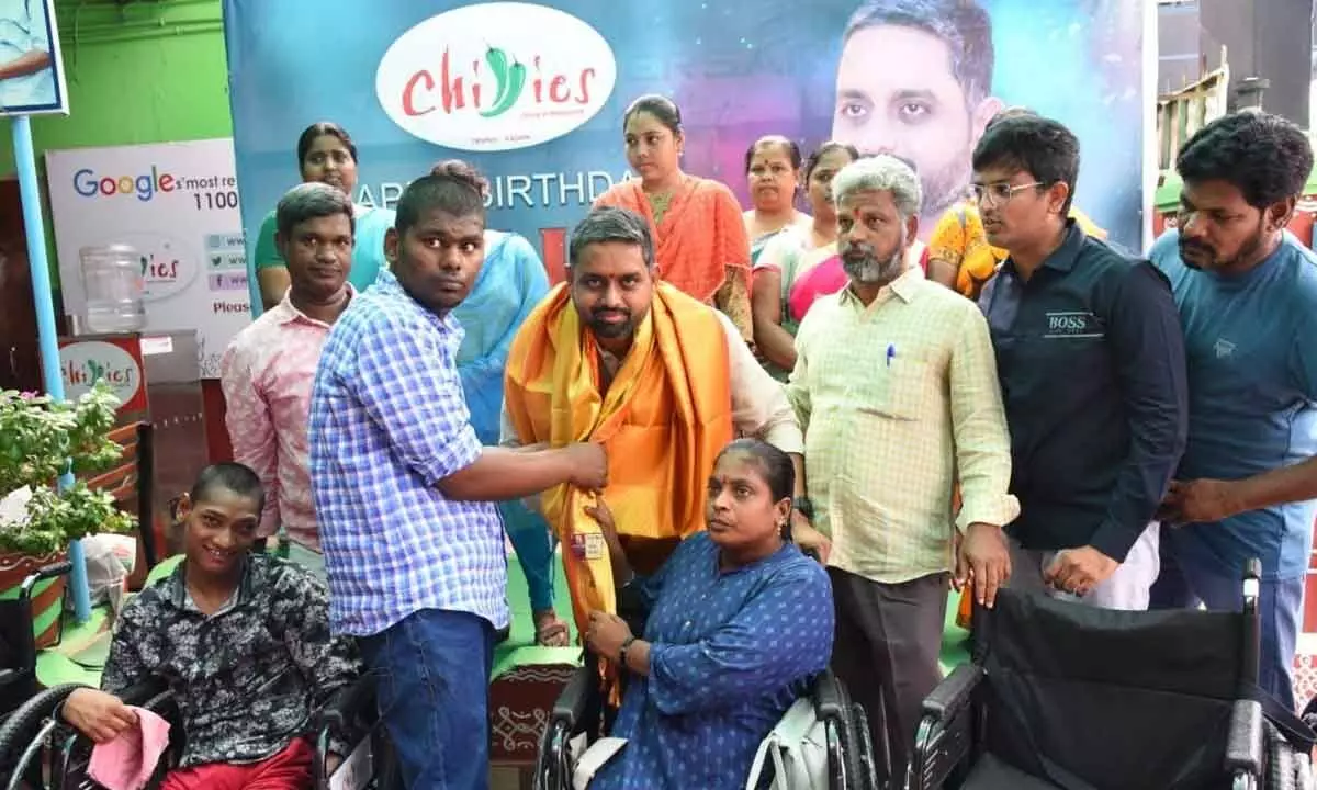 Chillies Hotels CEO Anji presenting a wheelchair to an orphan in Tirupati on Wednesday