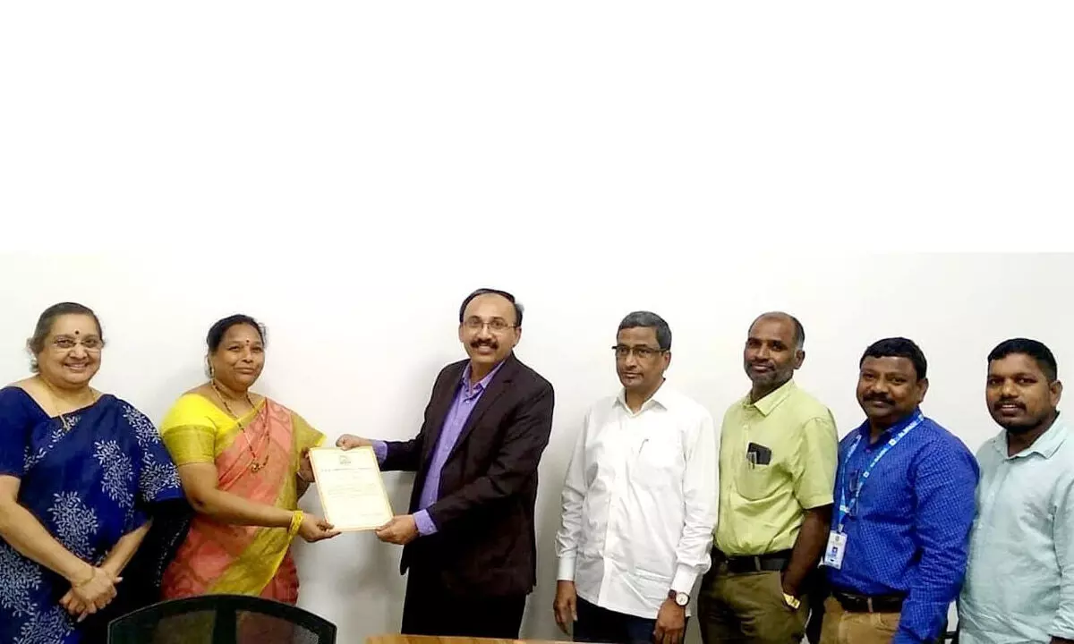 Dean of Commerce of Dr BR Ambedkar Open University Anand Pawar presenting Ph D certificate to lecturer N Sree Lakshmi in Hyderabad