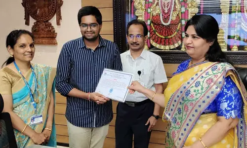 TTD JEO Sada Bhargavi congratulating N Bharadwaja for winning prize money of Rs 50,000 for doing research in Ayurveda, in Tirupati on Monday