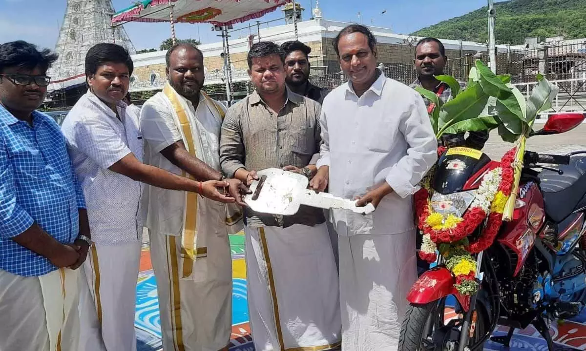 Hero MotoCorp company representative Vijay Kannan handing over key of a two-wheeler to TTD official Janakiram Reddy at Tirumala on Tuesday