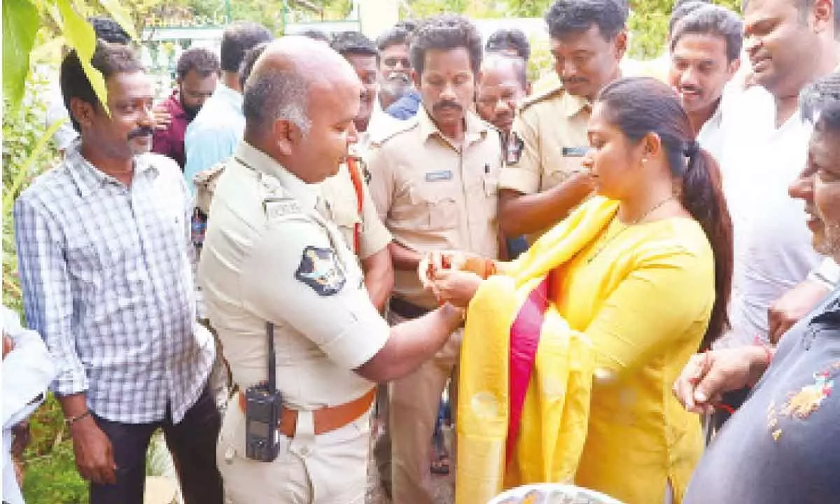 Bojjala Rishitha Reddy, wife of TDP Srikalahasti in-charge  Sudheer Reddy, tying Rakhi to a police officer, in Srikalahasti  on Wednesday