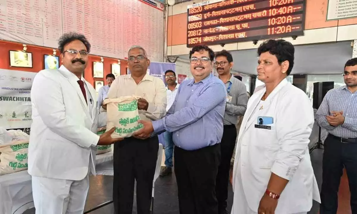 DRM Saurabh Prasad distributing a bag of seed balls to the staff during a programme held in Visakhapatnam on Monday