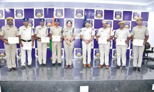 Prakasam district SP Malika Garg and Additional SP K Nageswara Rao appreciating Giddalur CI Deva Prabhakar and his team for rescuing two youths from drowning, in Ongole on Monday