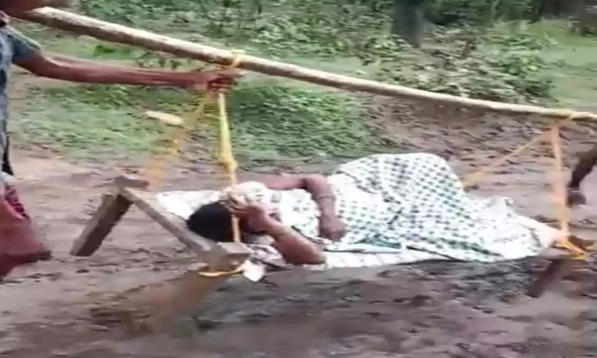 A tribal pregnant woman being shifted on doli for delivery in hospital in Cherla mandal under Kothagudem district on Tuesday