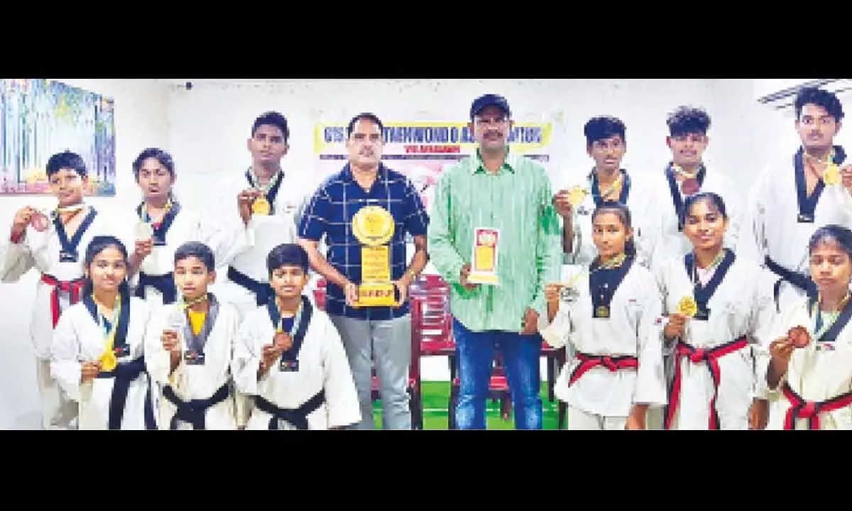 Olympic association president Gurana Ayyalu and Ch Venugopalarao with taekwondo players in Vizianagaram on Wednesday