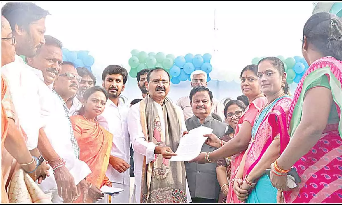 City MLA and TTD Chairman Bhumana Karunakar Reddy giving away copy of orders lifting ban on registration of land, in Tirupati on Wednesday