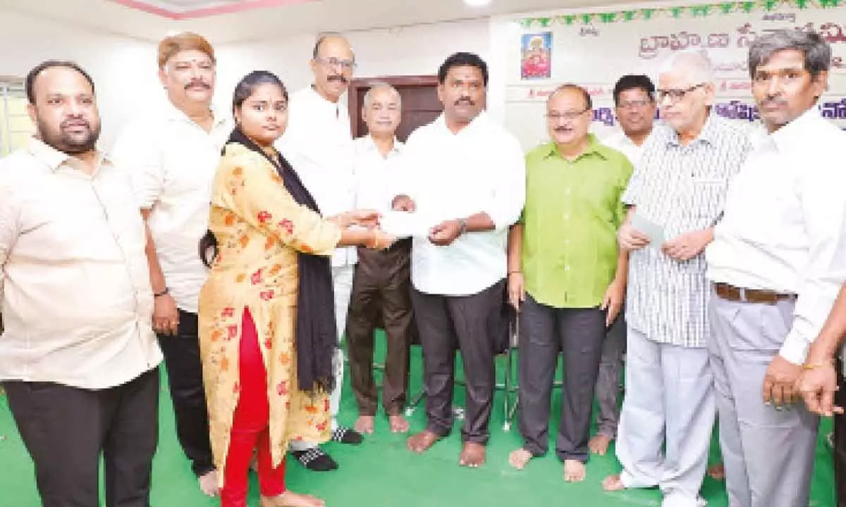 Mayor Kavati Siva Naga Manohar Naidu distributing scholarship to a girl student in Guntur on Sunday