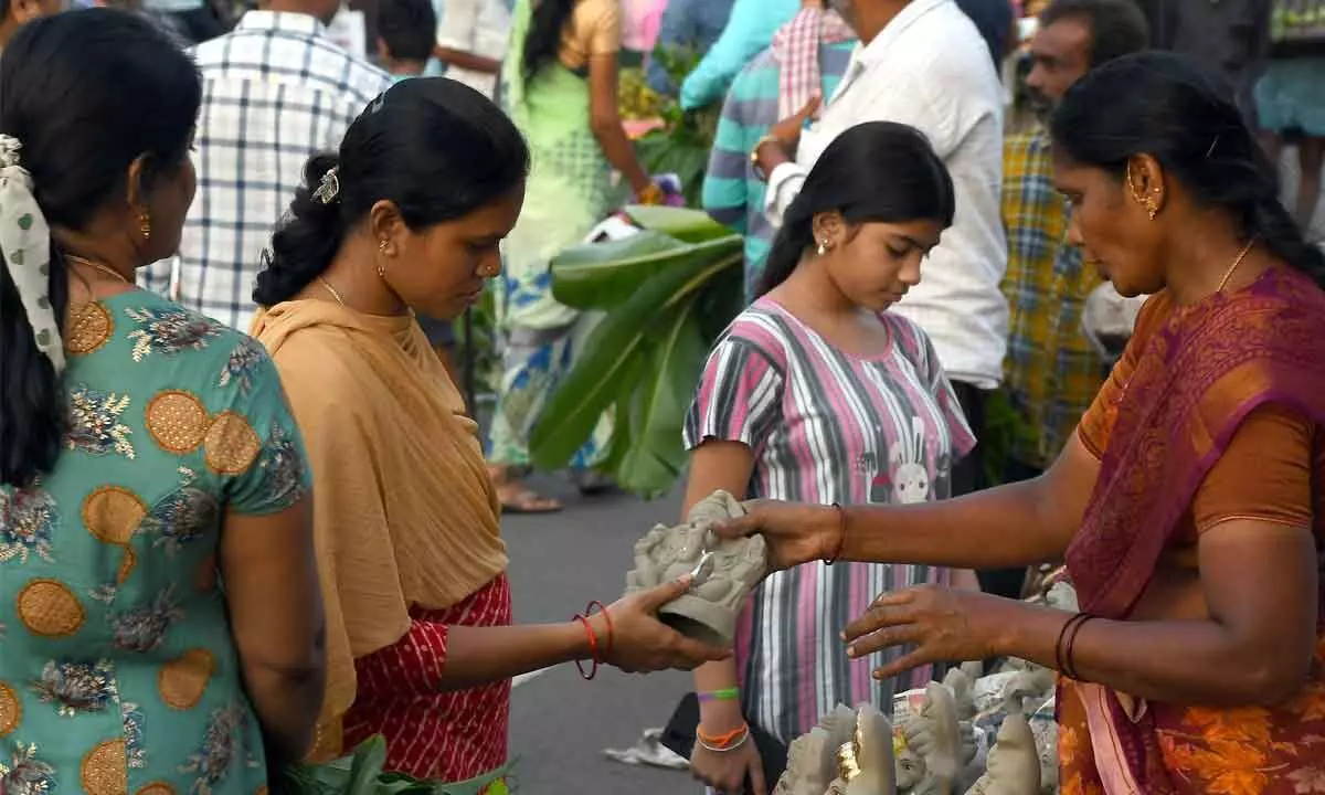 A woman purchasing Ganesh idol at a market in Vijayawada on Sunday