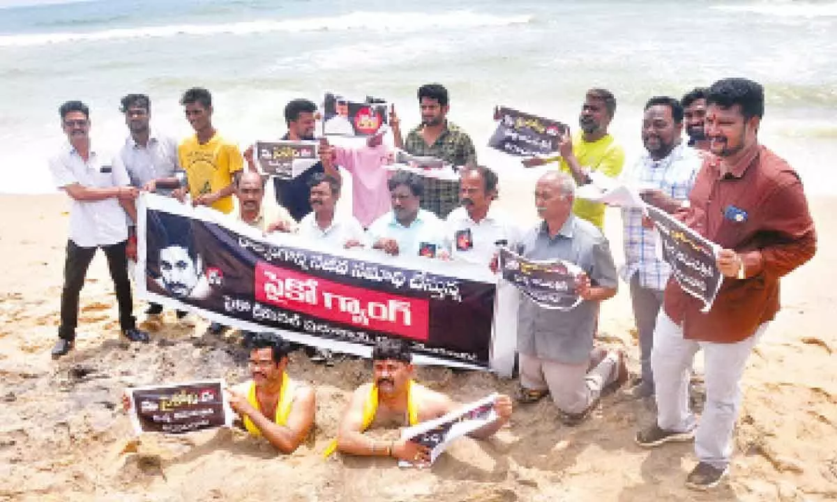 TDP leaders staging a protest by covering themselves in the beach sand at the Beach Road in Visakhapatnam on Friday