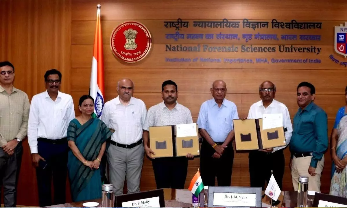 Authorities of VR Siddhartha Engineering College and National Forensic Sciences University showing the MoU copies at Ahmedabad in Gujarat on Monday