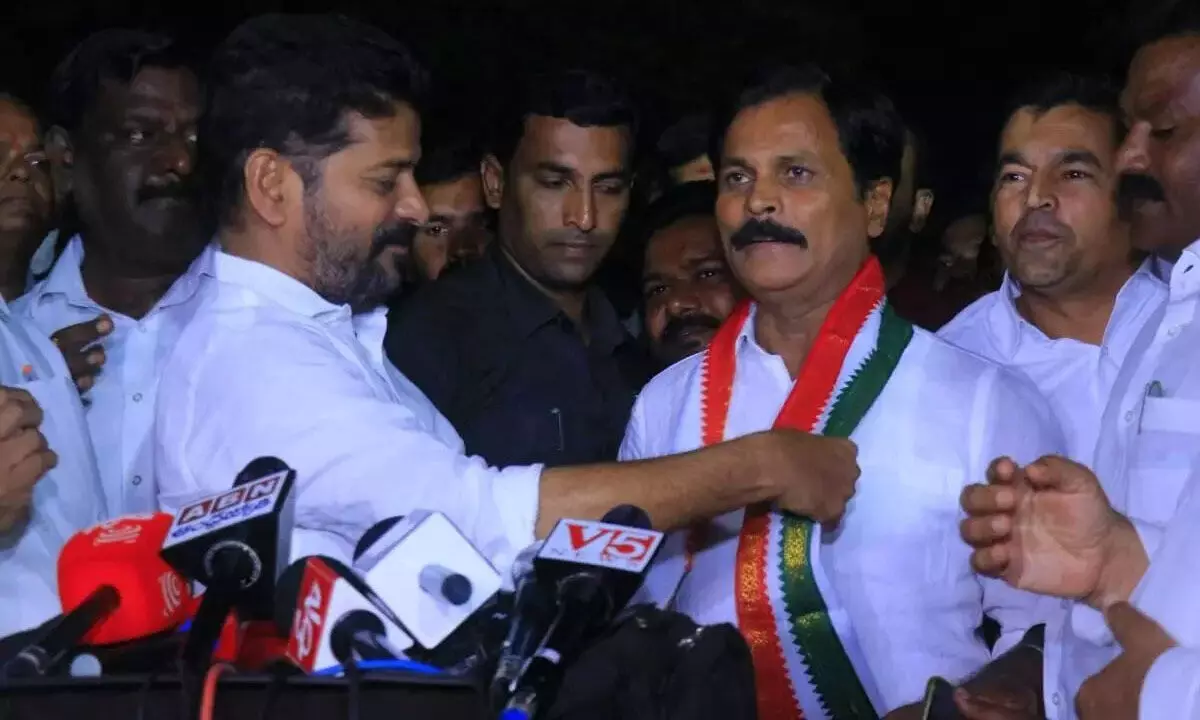 TPCC chief Revanth Reddy welcoming  Kumbham Anil Kumar Reddy into party fold offering party kanduva in Hyderabad on Monday