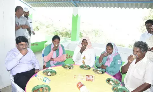 Collector Siva Shankar Lotheti having coffee with the sanitation workers in the CLAP Mithra programme in Narasingapadu village on Tuesday
