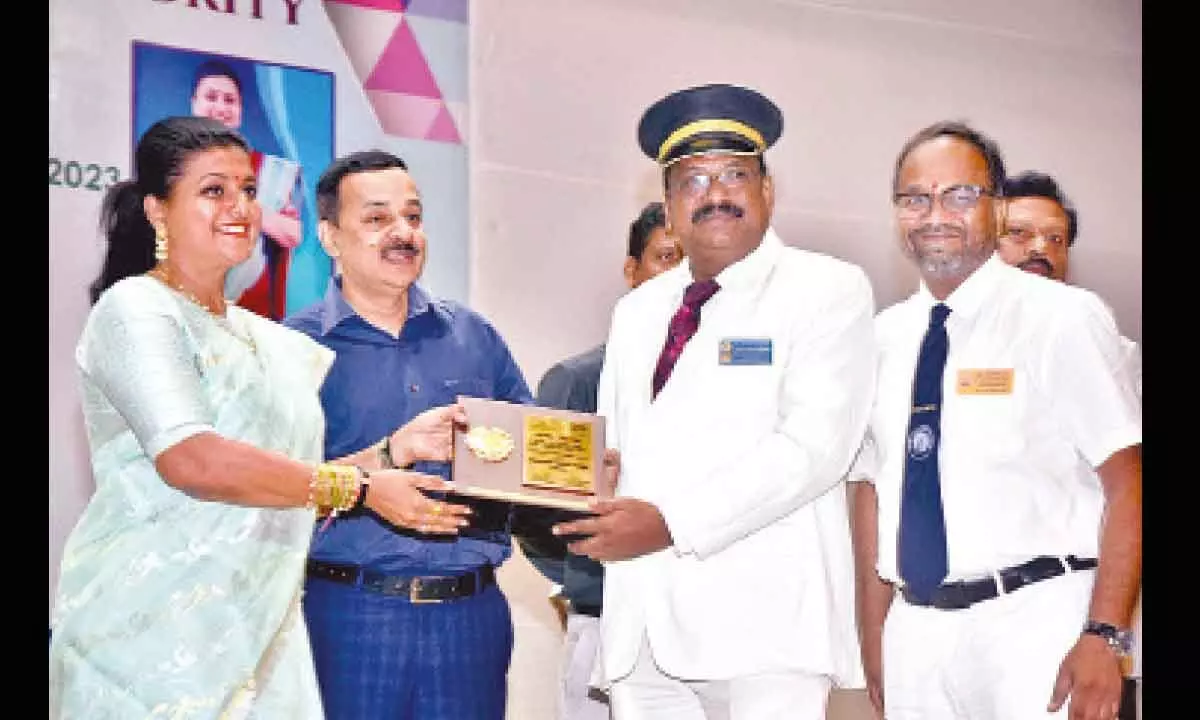 Minister for Tourism and Culture RK Roja presenting Best Tourist-Friendly Station award to Vijayawada railway station official in Vijayawada on Wednesday