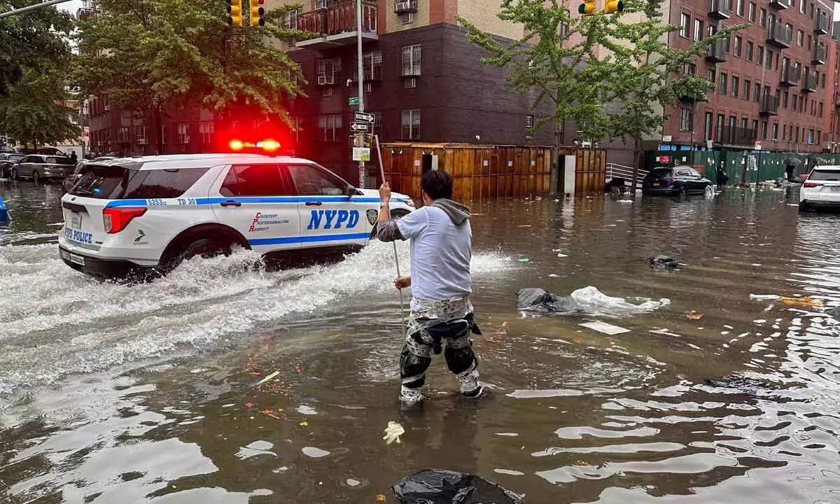 A man works to clear a drain in flood waters on Friday in the Brooklyn borough of New York. A potent rush-hour rainstorm has swamped the New York metropolitan area