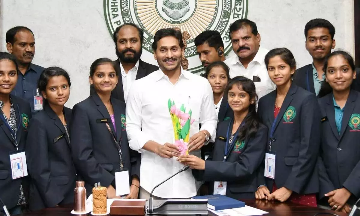Chief Minister Y S Jagan Moha Reddy with the government school students who recently returned from US trip, at his camp office in Tadepalli on Monday